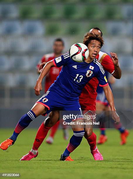 Hiroshi Kiyotake of Japan battles for the ball with Osama Omari of Syria during the 2018 FIFA World Cup Asian Group E qualifying match between Syria...