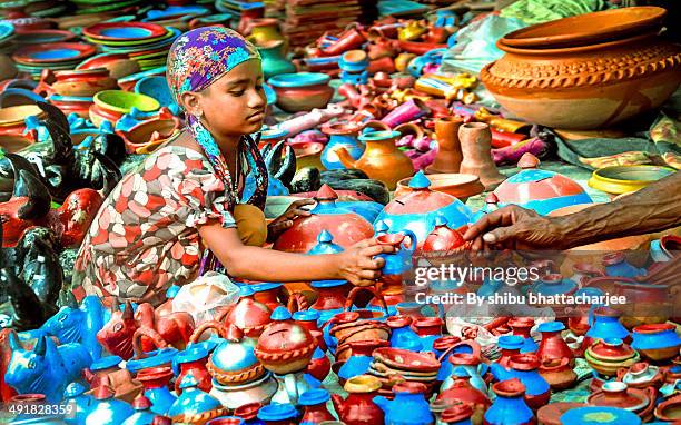 buying soil made toys in the village fair - bengali girl - fotografias e filmes do acervo