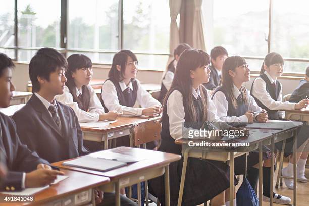 japanese students listening to the teacher in the classroom - japan 12 years girl stock pictures, royalty-free photos & images