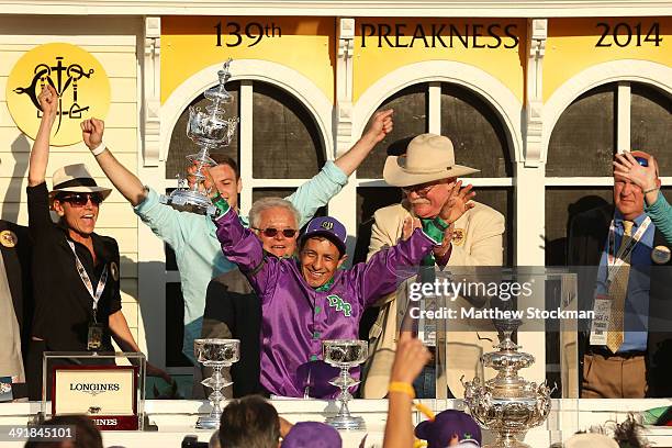 Jockey Victor Espinoza celebrates with owner Steve Coburn and trainer Art Sherman after winning the 139th running of the Preakness Stakes atop...