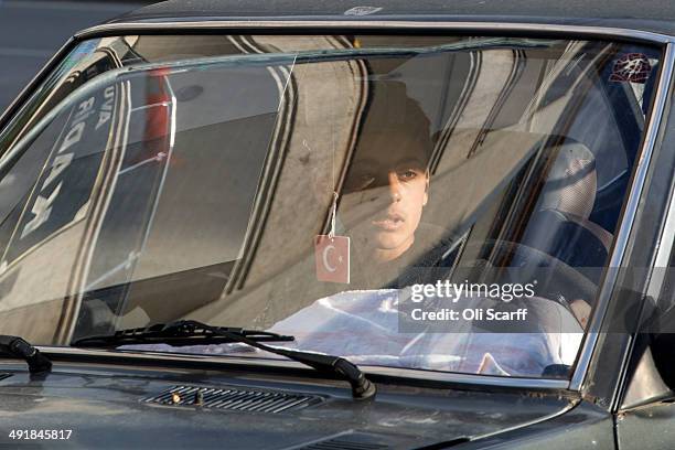 Young man travels in a car through Soma town centre with a air freshener displaying the Turkish national flag on May 17, 2014 in Soma, Turkey....