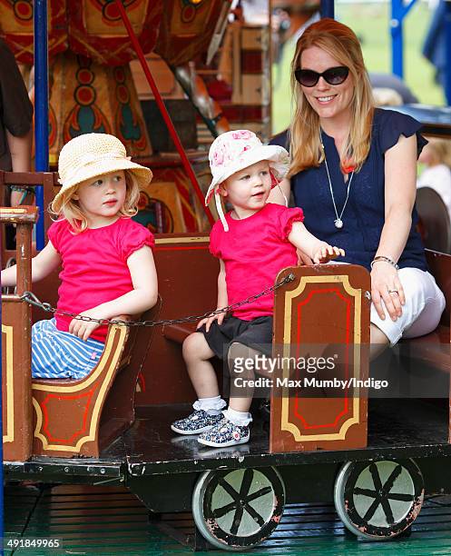 Autumn Phillips and daughters Savannah Phillips and Isla Phillips ride a merry go round during day 4 of the Royal Windsor Horse Show at Home Park on...