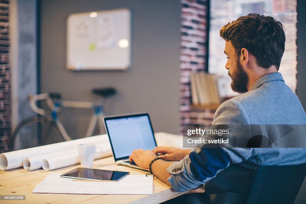 Homme travaillant sur bureau moderne.