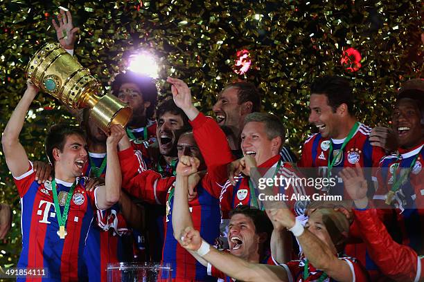 Captain Philipp Lahm of Bayern Muenchen lifts the trophy with team mates to celebrate victory after the DFB Cup Final match between Borussia Dortmund...