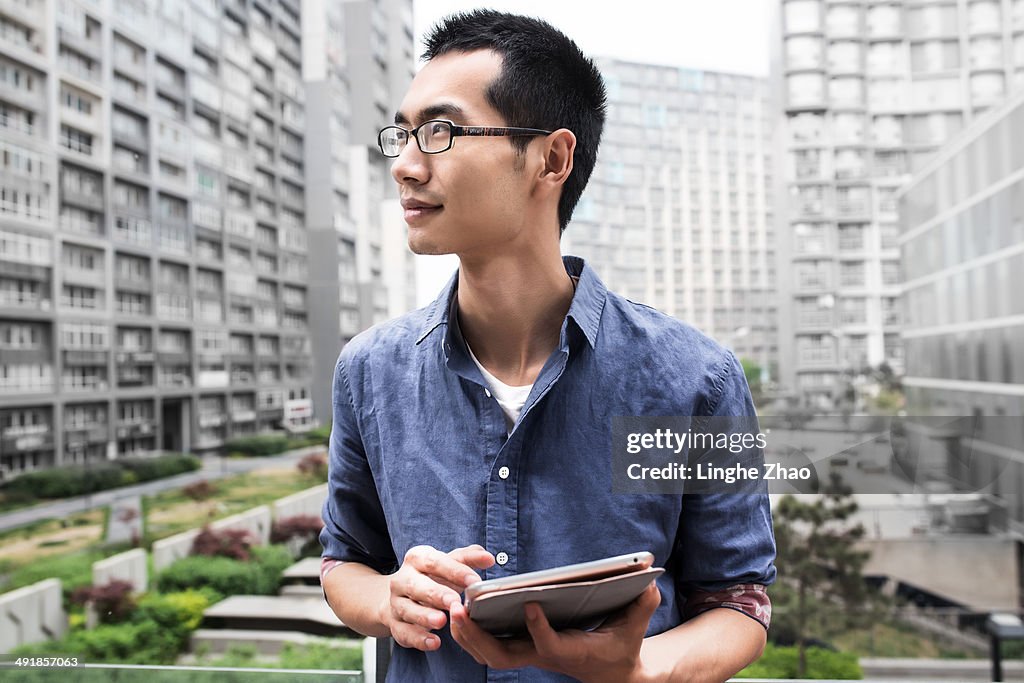 Asian man holding a tablet computer