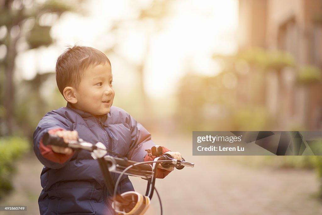 Boy smiling and riding bicycle.