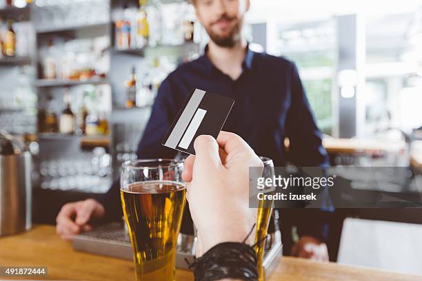 mann bezahlen mit kreditkarte für bier im pub - buying beer stock-fotos und bilder