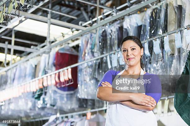 confident hispanic woman in her dry cleaning store - wasserette stockfoto's en -beelden