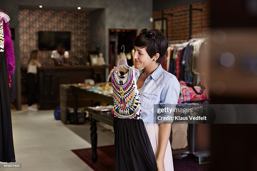 Woman trying dress in front of mirror