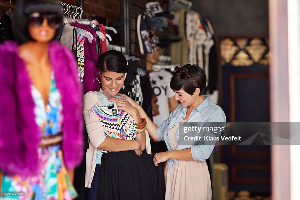 Girlfriends trying on dress and having fun