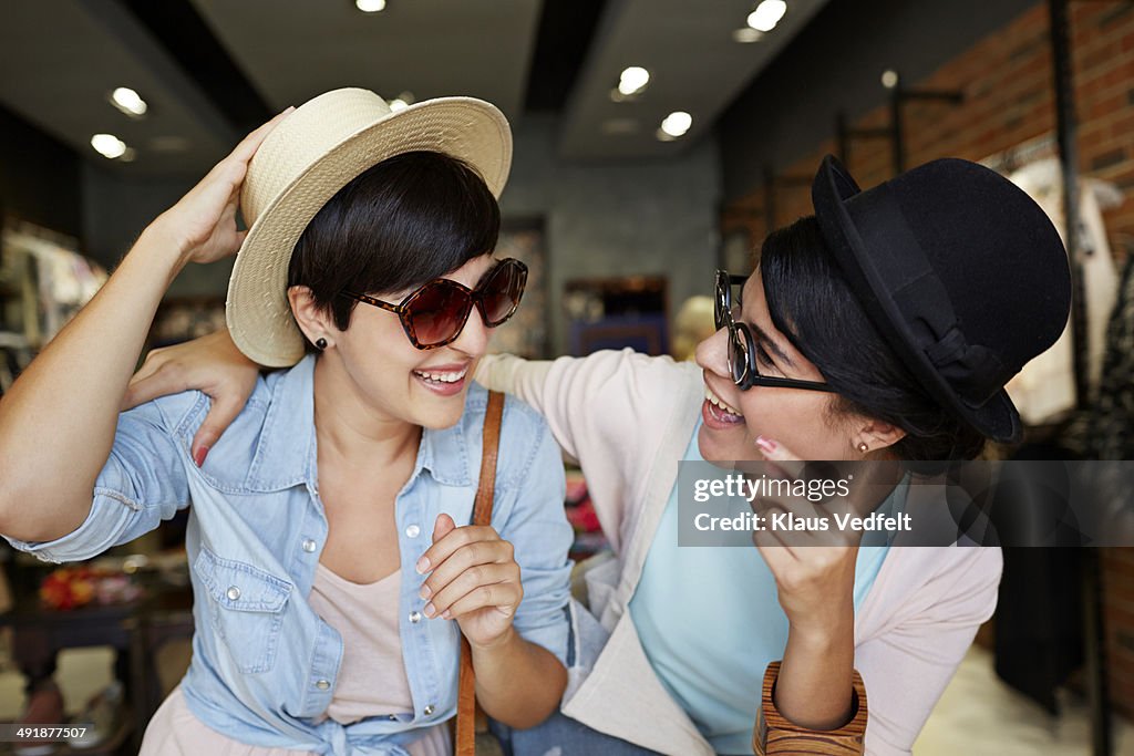 Girlfriends trying hats & glasses and having fun