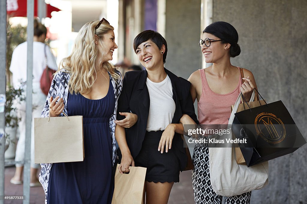 Girlfriends walking together with shopping bags