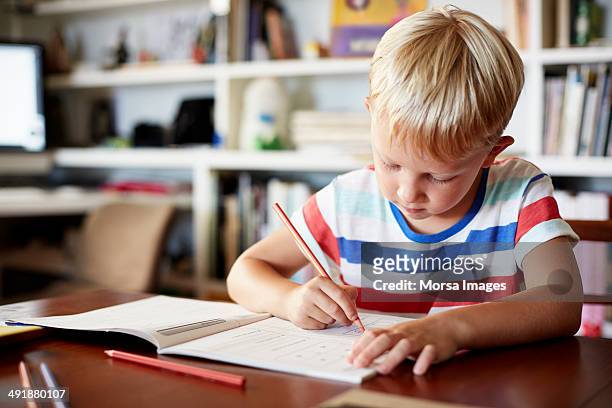 boy coloring at table - kids homework stock pictures, royalty-free photos & images