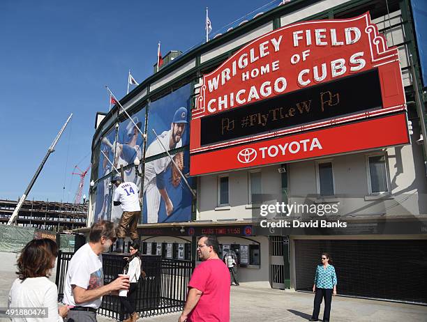 People in front of the Cubs marquee on October 8, 2015 around Wrigley Field in Chicago, Illinois.