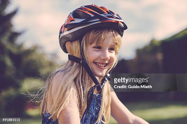happy young girl cycling. - cycling helmet stock-fotos und bilder