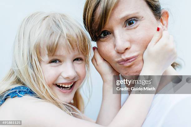 mother and daughter making faces. - making a face stock-fotos und bilder