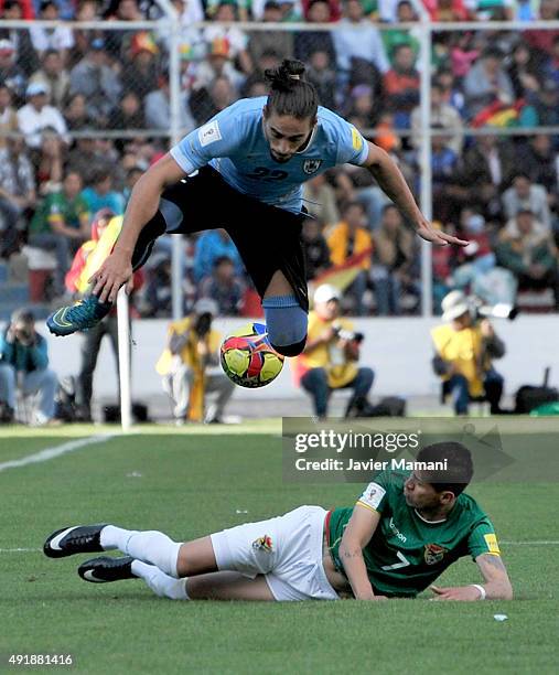 Martin Caceres of Uruguay jumps over Juan Carlos Arce of Bolivia during a match between Bolivia and Uruguay as part of FIFA 2018 World Cup Qualifier...