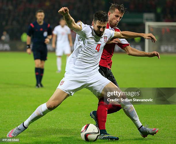 Nenad Tomovic of Serbia is challenged by Ermir Lenjani of Albania during the Euro 2016 qualifying football match between Albania and Serbia at the...