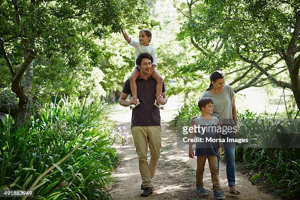 two generation family walking in park - day 6 stock-fotos und bilder