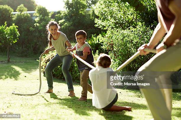 family playing tug-of-war in park - challenge competition imagens e fotografias de stock