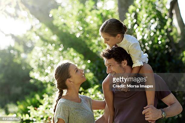 happy parents with daughter in park - parents and children enjoying park photos et images de collection