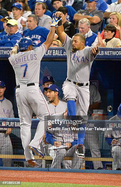 The Texas Rangers' Rougned Odor celebrates with teammate Delino DeShields after DeSheilds scored a run during the third inning against the Toronto...