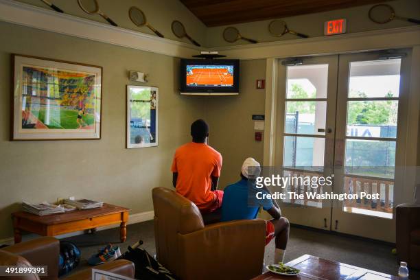 Twins Francis Tiafoe, L, and Franklin Tiafoe study television tennis matches after the rains stopped their outdoor games at the Junior Tennis...