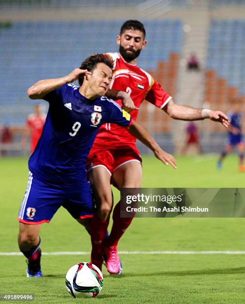 Shinji Okazaki of Japan is fouled by Ahmad Alsalih of Syria in the penalty area during the 2018 FIFA World Cup Asian Group E qualifying match between...