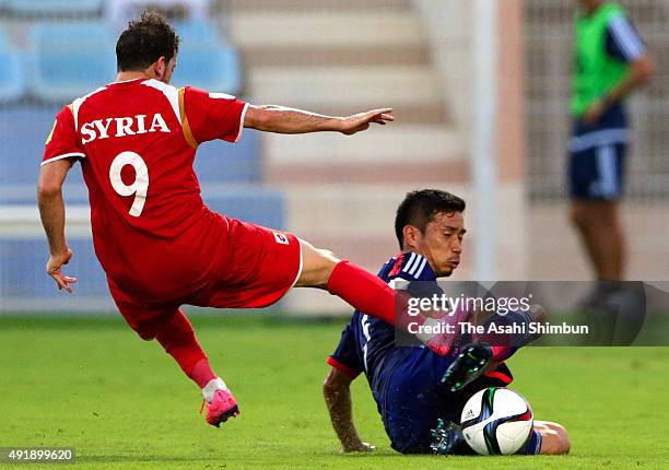 Yuto Nagatomo of Japan tackles Mahmoud Al Mawas of Syria during the 2018 FIFA World Cup Asian Group E qualifying match between Syria and Japan at...