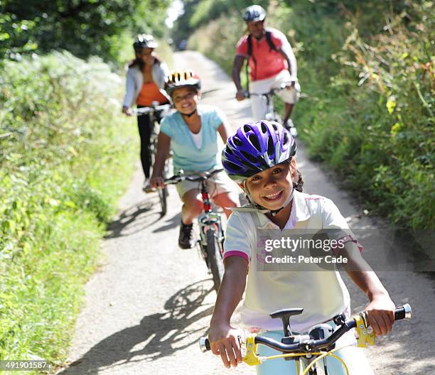 family cycling on country lane - family cycling holiday stock pictures, royalty-free photos & images