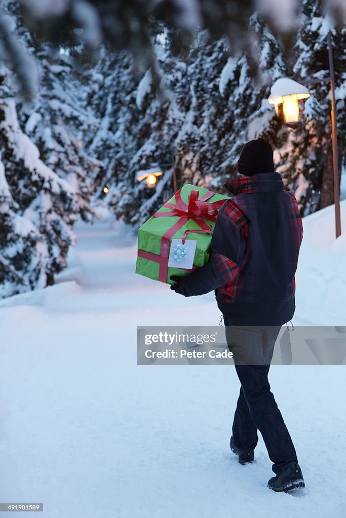 Man carrying present in snow