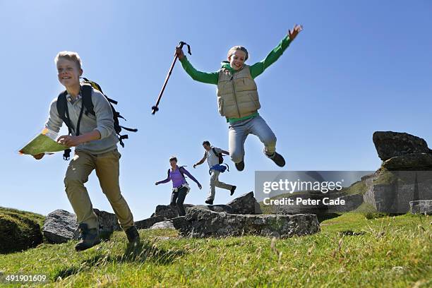 family hiking, jumping over rocks - kids hiking stock pictures, royalty-free photos & images