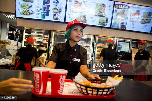 An employee handles a tray of food inside a KFC restaurant, operated by Yum! Brands Inc. KFC and Yoma Strategic Holdings, in Yangon, Myanmar, on...