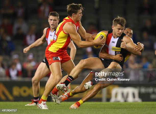 Maverick Weller of the Saints is tackled by David Swallow and Harley Bennell of the Suns during the round nine AFL match between the St Kilda Saints...