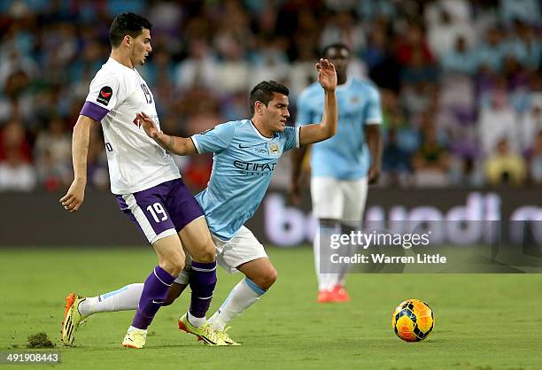 Marcos Lopez of Manchester City is tackled by Mohmanad Salem of Al Ain during the friendly match between Al Ain and Manchester City at Hazza bin...