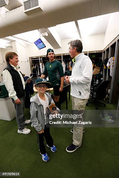 Michael Lewis and his son stand in the clubhouse with Barry Zito and General Manager Billy Beane of the Oakland Athletics prior to the game against...