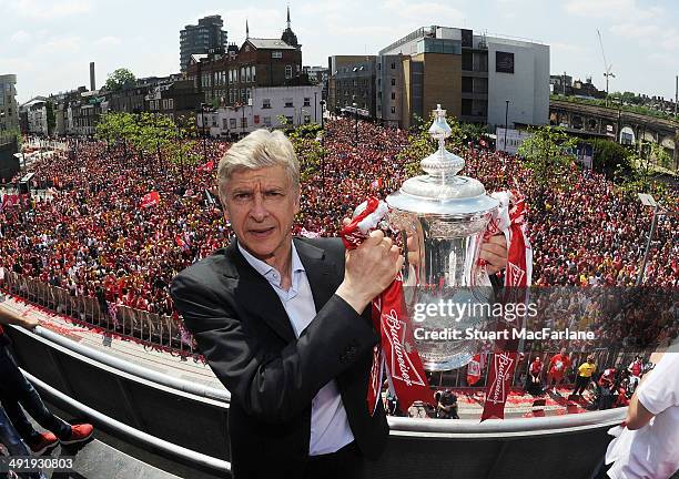 Arsenal manager Arsene Wenger poses with the trophy at the Victory Parade after winning the FA Cup Final on May 18, 2014 in London, England.