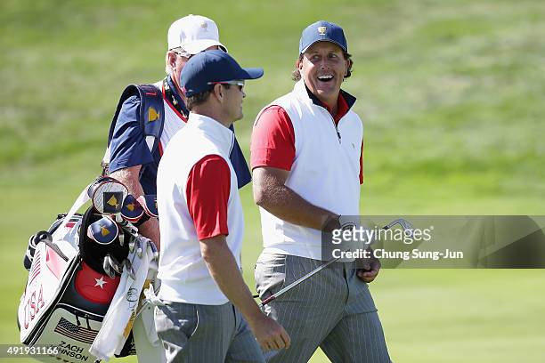 Phil Mickelson of the United States Team celebrates with his playing partner Zach Johnson after holing a bunker shot on the 12th hole during the...