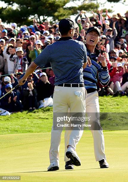 Danny Lee and Sang-Moon Bae of the International Team celebrate a putt to win the match on the 18th green during the Friday four-ball matches at The...