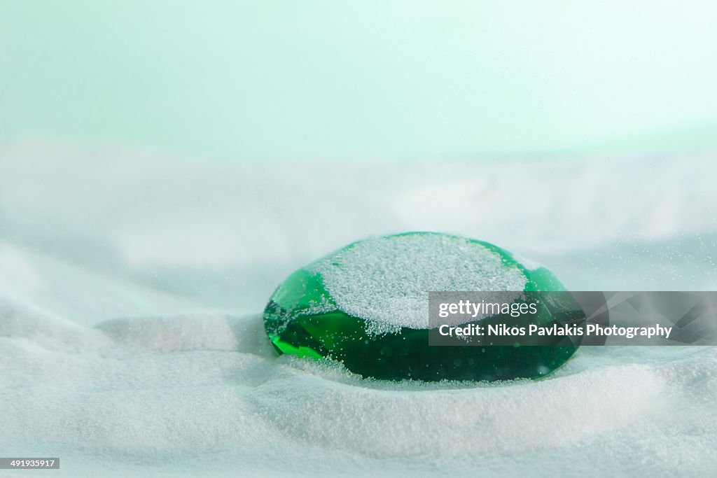Green emerald sunk through the sand.