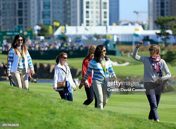 Angie Watson of the United States leads a group of team wives on the first hole during the Friday four-ball matches at The Presidents Cup at Jack...