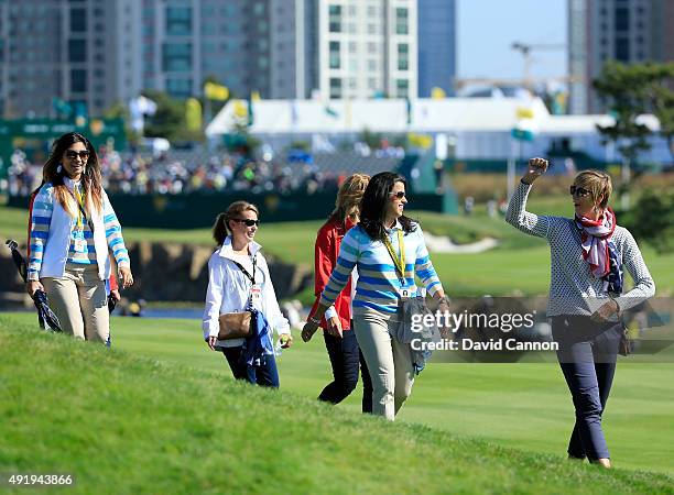 Angie Watson of the United States leads a group of team wives on the first hole during the Friday four-ball matches at The Presidents Cup at Jack...