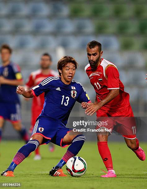 Hiroshi Kiyotake of Japan battles for the ball with Osama Omari of Syria during the 2018 FIFA World Cup Asian Group E qualifying match between Syria...