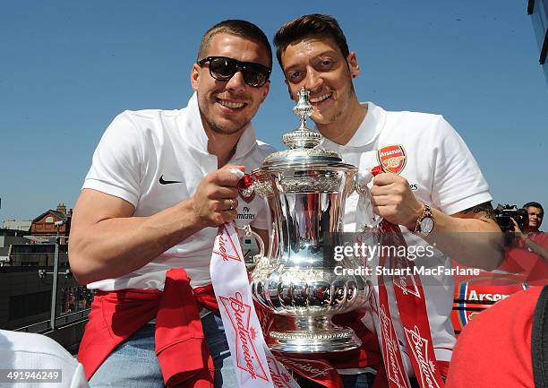 Lukas Podolski and Mesut Ozil pose at the Arsenal Victory Parade after winning the FA Cup Final on May 18, 2014 in London, England.