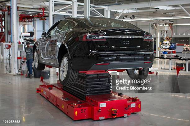 Tesla Model S automobile stands on a hydraulic platform during wheel fitting on the final assembly line at the Tesla Motors Inc. Factory in Tilburg,...