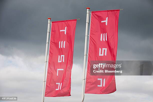 The Tesla logo sits on banners flying outside the Tesla Motors Inc. Factory in Tilburg, Netherlands, on Thursday, Oct. 8, 2015. Tesla said it...
