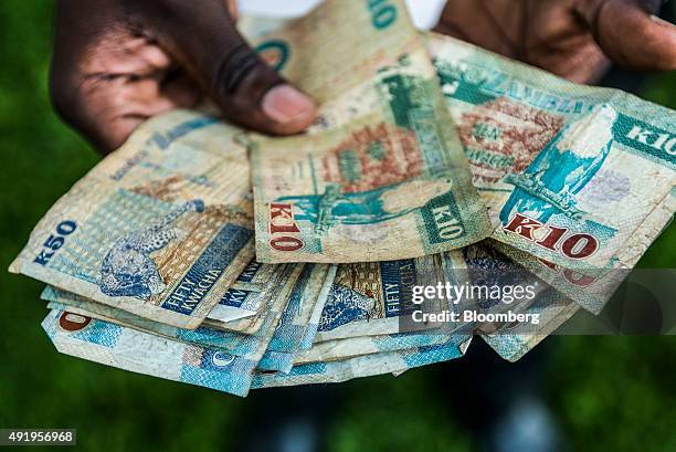 Man holds a collection of Zambian kwacha banknotes in this arranged photograph in Lusaka, Zambia, on Thursday, Oct. 8, 2015. Zambian Finance Minister...