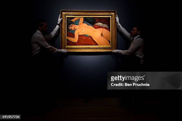 Art handlers hang the painting 'Nu couche' by artist Amedeo Modigliani during the preview ahead of the artist's muse: a curated evening sale in...