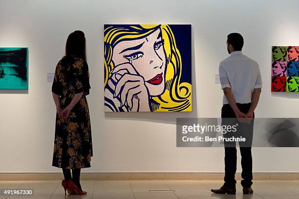 Gallery staff look at 'Crying Girl' by artist Roy Lichtenstein during the preview ahead of the artist's muse: a curated evening sale at Christie's...
