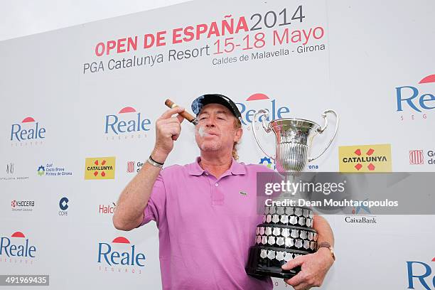 Miguel Angel Jimenez of Spain smokes his cigar and poses with the trophy after winning the Open de Espana held at PGA Catalunya Resort on May 18,...